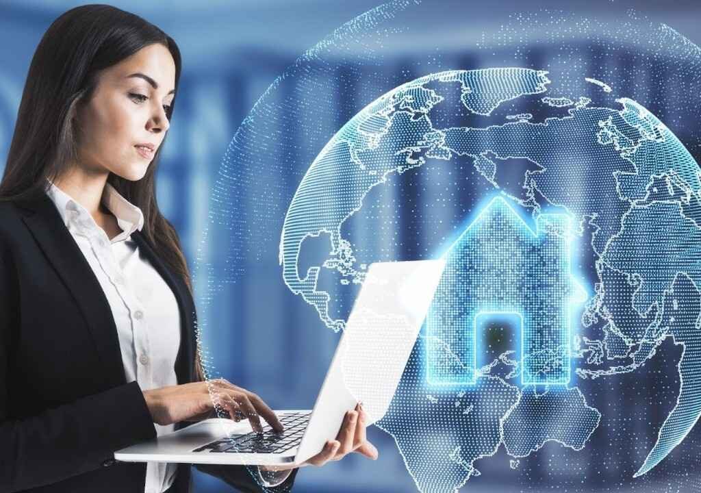 Real estate agent researching deal management software on laptop with digital icons representing real estate technology