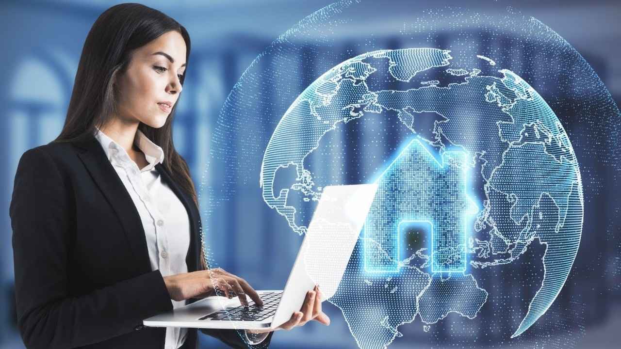 Real estate agent researching deal management software on laptop with digital icons representing real estate technology